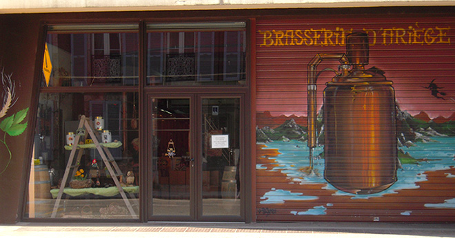 Photo de la facade de la brasserie avec la vitrine et la peinture Brasserie d'Ariège